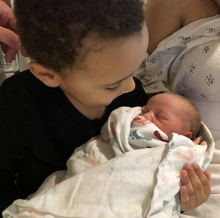 Son holding baby sibling